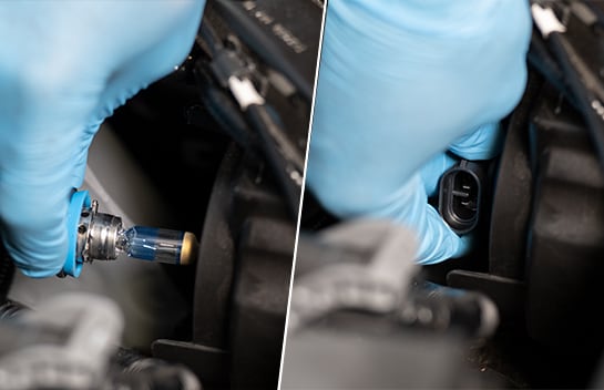 Hand holding new headlight bulb at the installation position