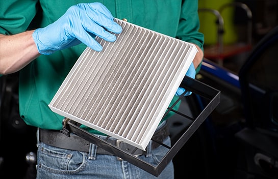 O’Reilly Auto Parts team member holding the old cabin air filter