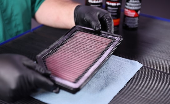 Auto parts professional holding an oiled engine air filter