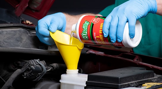 Pouring new O'reilly brake fluid into 2008 Dodge Nitro master cylinder