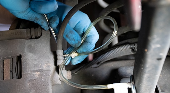 Closing brake bleeder valve to carefully remove brake bleeder hose