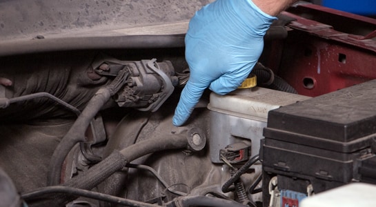 blue gloved hand pointing out vacuum line