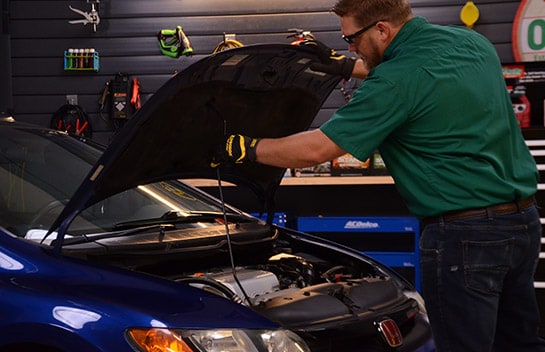 Photo of a blue Honda Civic, parked on a level surface with the hood propped open. 