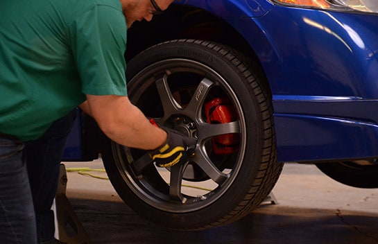 Civic’s front wheels lug nuts being removed using a torque wrench.