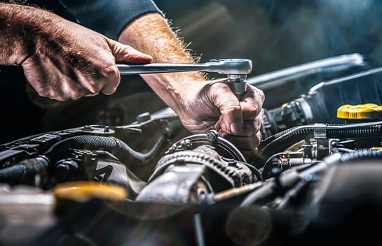 Mechanically inspecting and repairing a vehicle’s engine. 