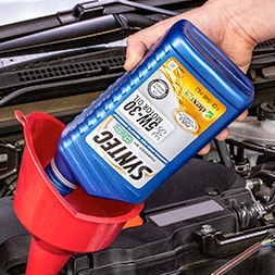 Syntec oil being poured in a funnel