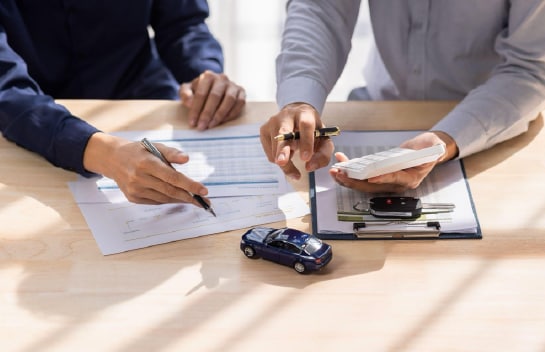 Two individuals going over vehicle paperwork