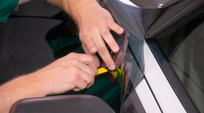 Close up of using a sharp knife to carefully trim the film