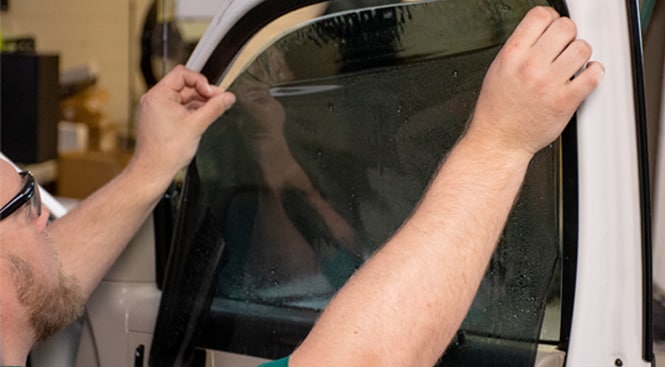 Sliding the film in place keeping in mind to leave a gap at the edge of the top of the window.