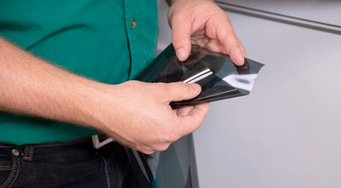 Looking at the different sides of the liner to identify the side that will be applied facing the window