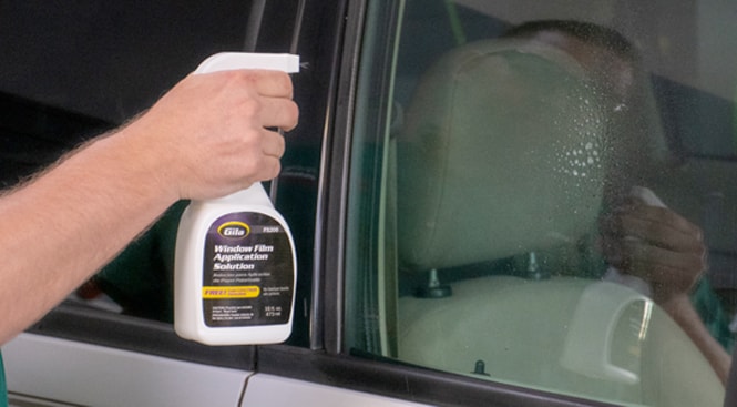 Spraying the outside of the window with Gila Window Film Application Solution