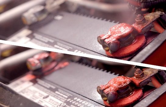 In two images, battery terminal protective spray is applied to the battery tray, leaving a red-colored foam.