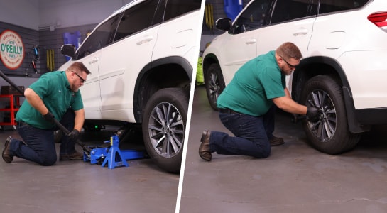 The Highlander is lowered using the floor jack and the lug nuts are torqued with a socket.