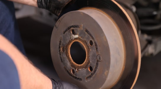 The old rotor is removed from the vehicle.