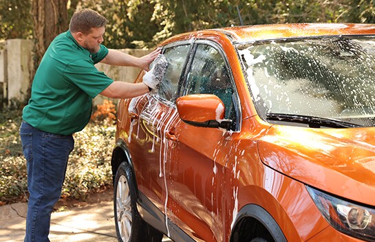 Soapy sponge being used on car