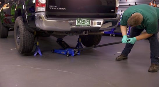 After loosening lug nuts on the rear wheels, lift and support the rear end, then remove the wheels.