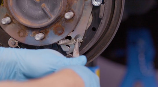 Use needle-nose pliers to install the lower return spring.