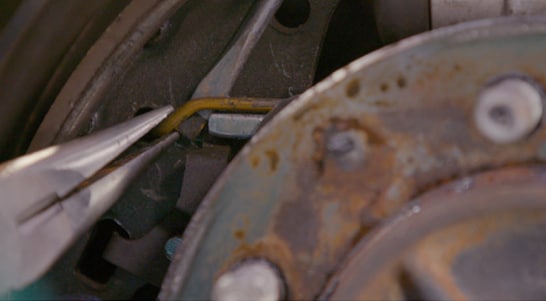 Remove the brake shoe return spring from the front brake shoe.