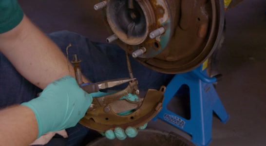 Detach the parking brake cable and remove the rear brake shoe.