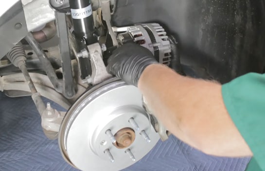 Lower the old alternator out of the wheel well.