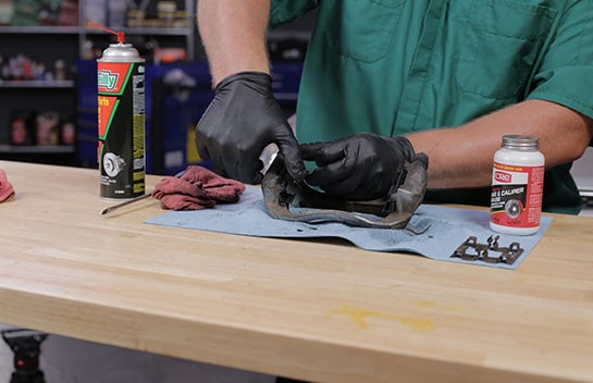 After applying silicone grease to the bracket, install the new brake hardware.