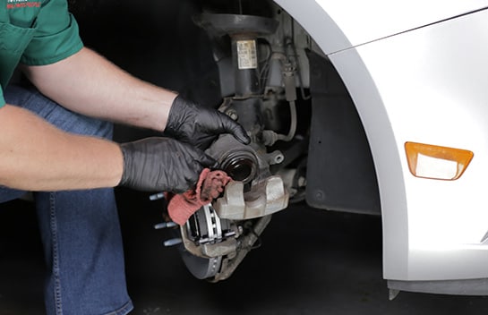 Clean the exposed portion of your caliper piston with brake cleaner on a towel or rag.