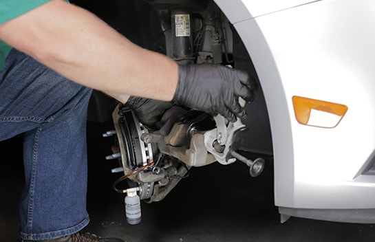 Use a compressor tool to compress the caliper piston, using an old brake pad to protect the piston.