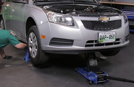 Use a jack and jack stands to lift and support the front end.