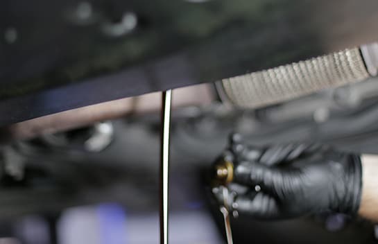 Remove the drain plug the rest of the way by hand, and let the oil drain.