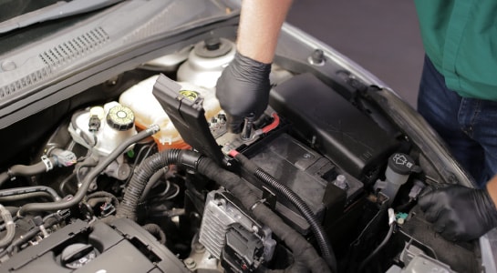 Use a 13mm socket to detach the cables under the fuse block cover.