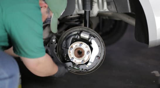 Install the new lower brake spring and the forward brake shoe.