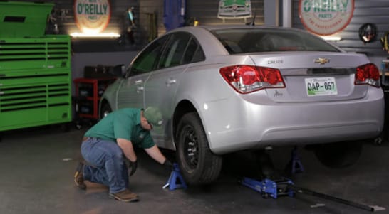 Use a floor jack and jack stands to lift and support the rear end of the car.