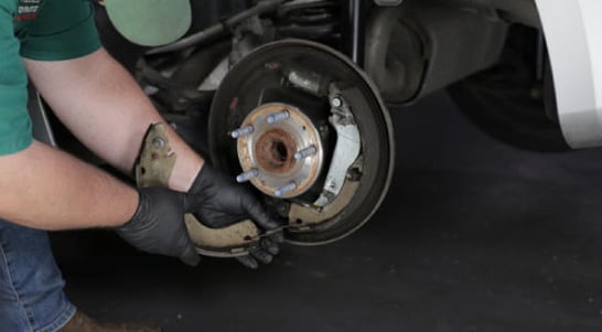 Remove the lower spring and the front brake shoe. 