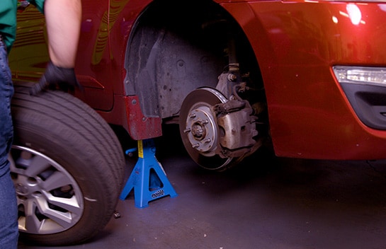 Once the front end is raised, remove the wheel on the side where you’ll be working.