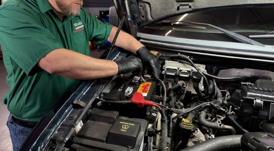 Auto parts professional disconnecting a negative battery cable