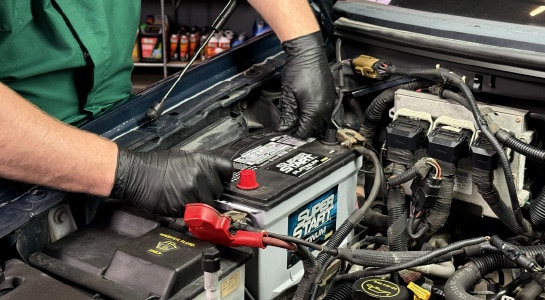 Auto Parts Professional installing a new battery in a Ford F-150