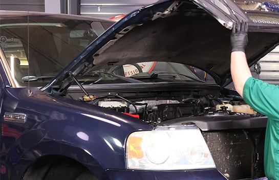 Auto parts professional opening a Ford F-150 hood