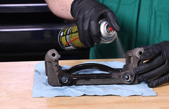 Auto Parts Professional cleaning a Ford F-150 caliper bracket