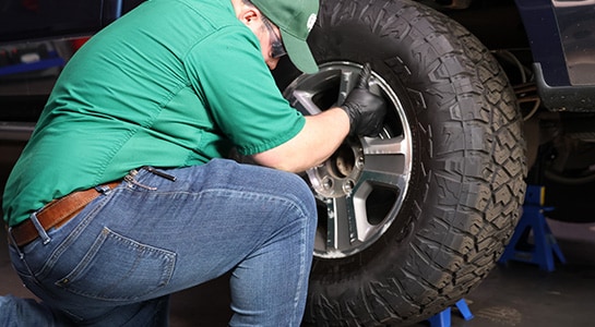 Auto parts professional reinstalling a rear wheel on a Ford F-150