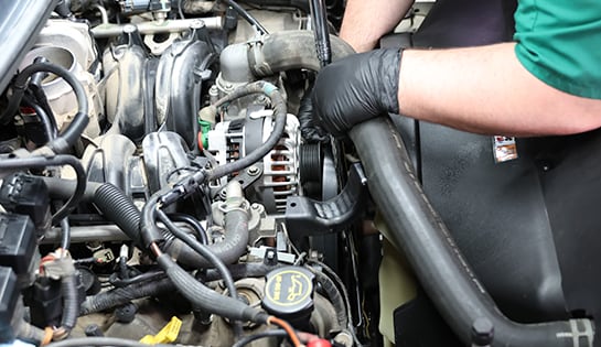 Auto parts professional turning a serpentine belt tensioner with a drive ratchet