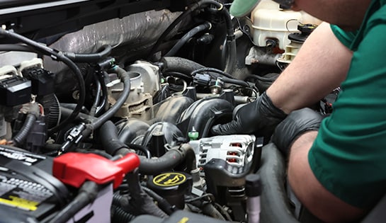 Auto parts professional installing a new alternator in a Ford F-150