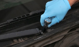 mechanic removing wiper blade arm
